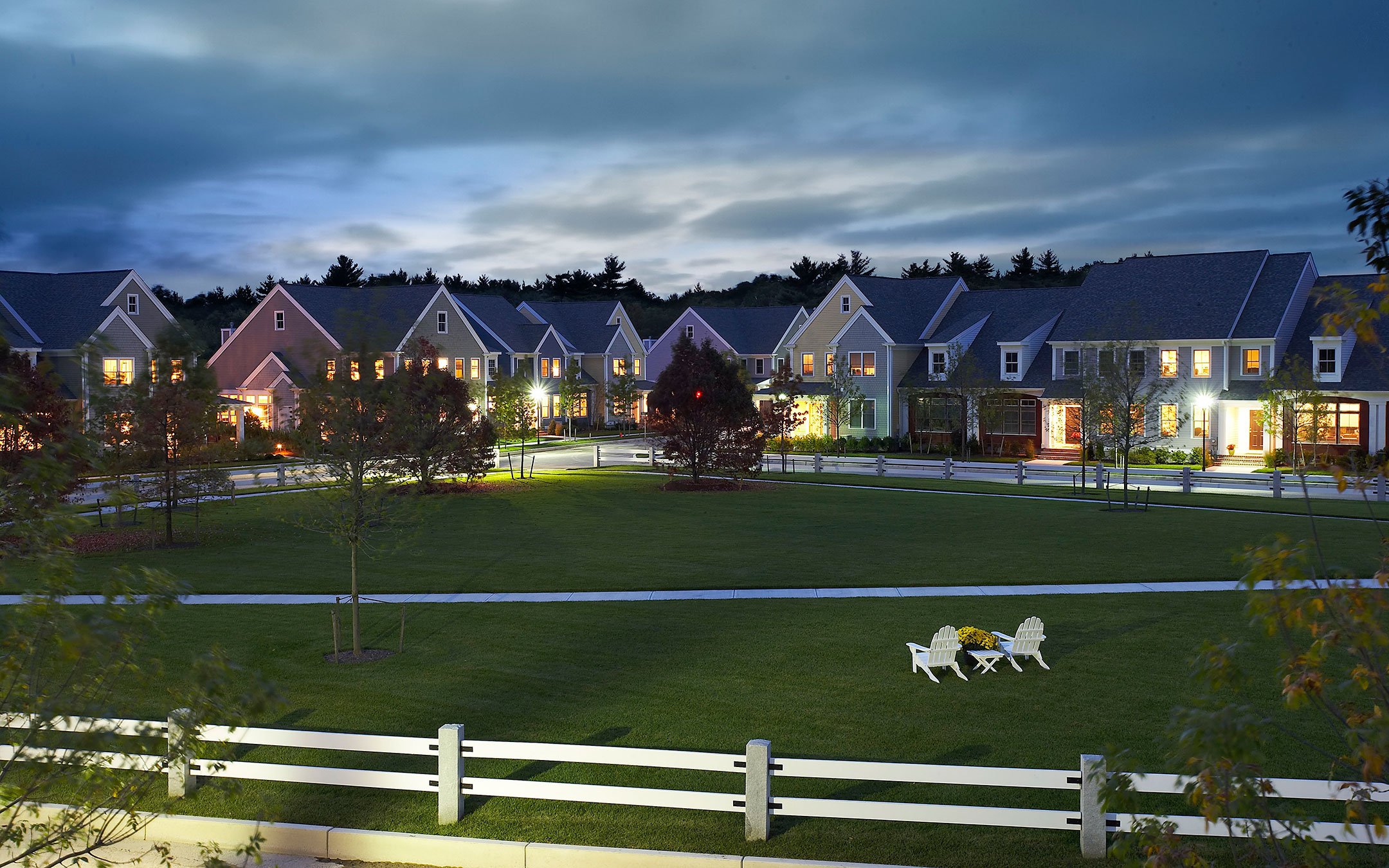 Village green and attached homes at dusk at Red Mill Village, NAHB award-winning 55+ community in Norton M