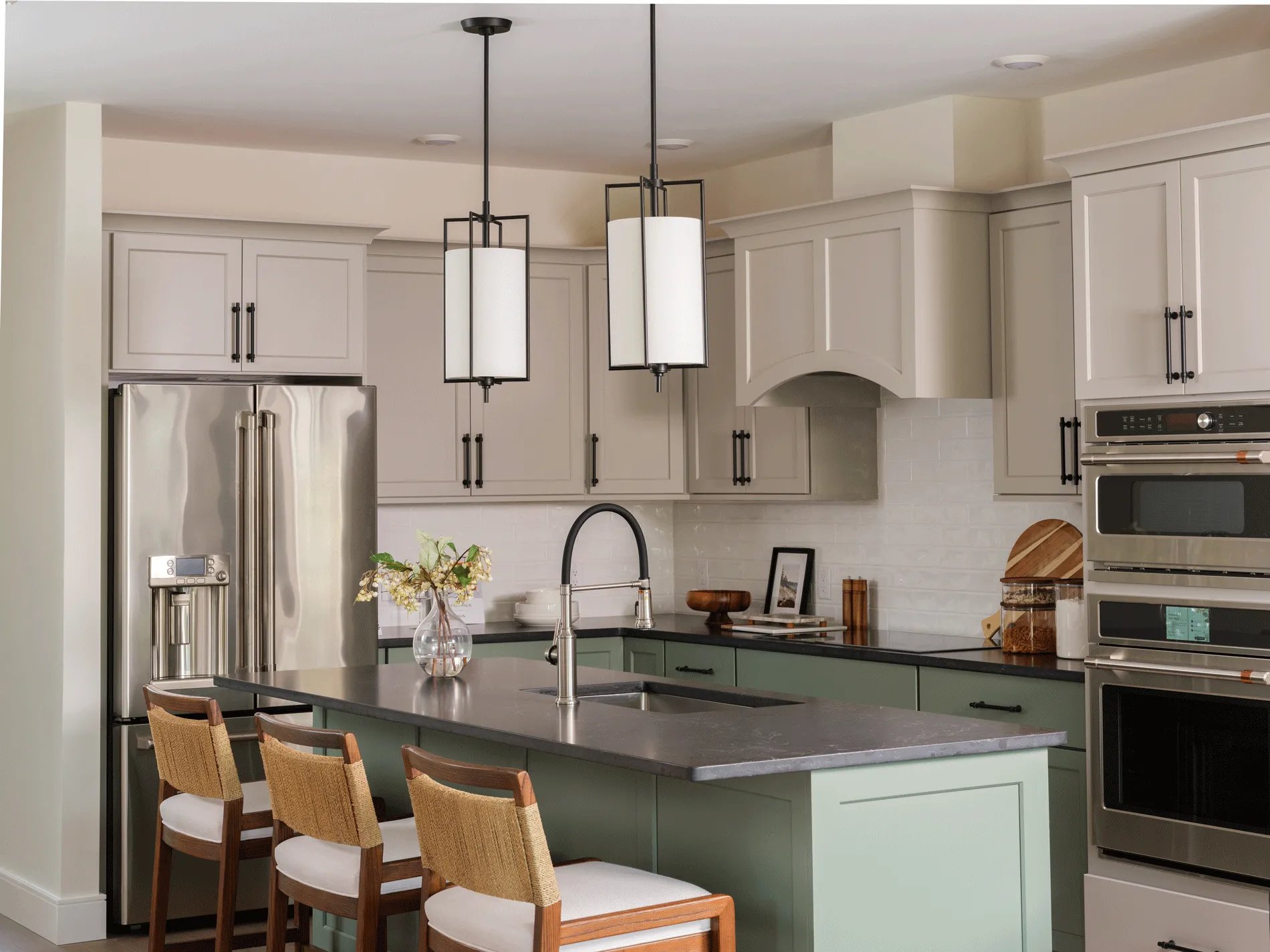 Kitchen with sage green island, quartz countertops, and stainless appliances in the Birch model at Larkwood new construction homes in Raynham MA