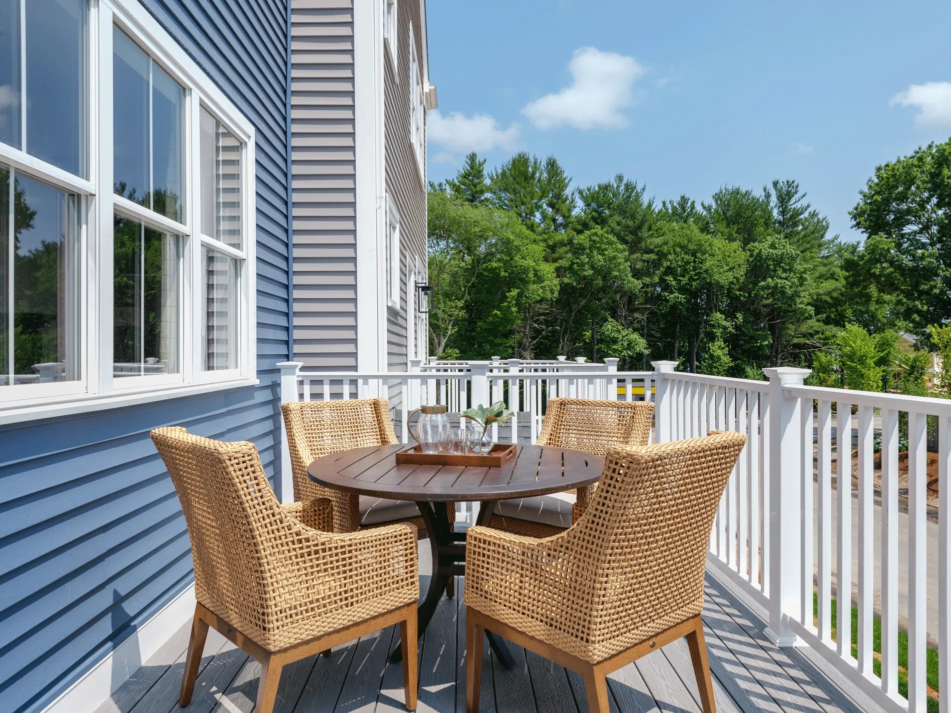 Private deck at a Larkwood townhome in Raynham MA with outdoor dining set and tree views