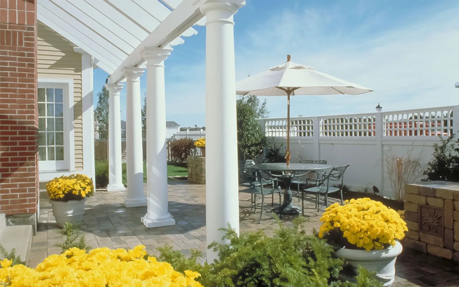 Covered patio with seasonal plantings and marina views at Chapman's Reach in Quincy MA