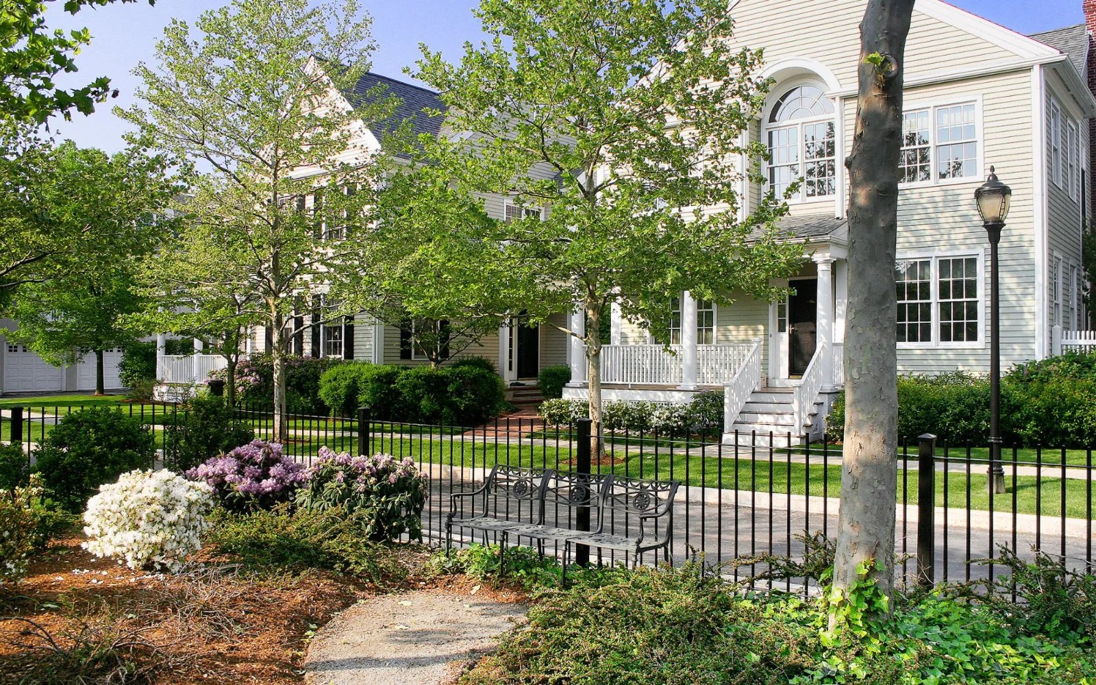Garden courtyard with perennial plantings and iron fence at Chapman's Reach, Marina Bay in Quincy MA