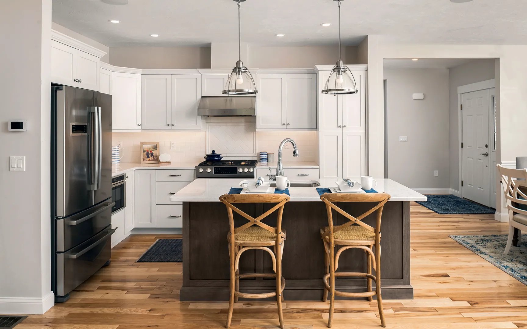 Chef kitchen with island seating and stainless appliances in Summer Reach model home Plymouth MA