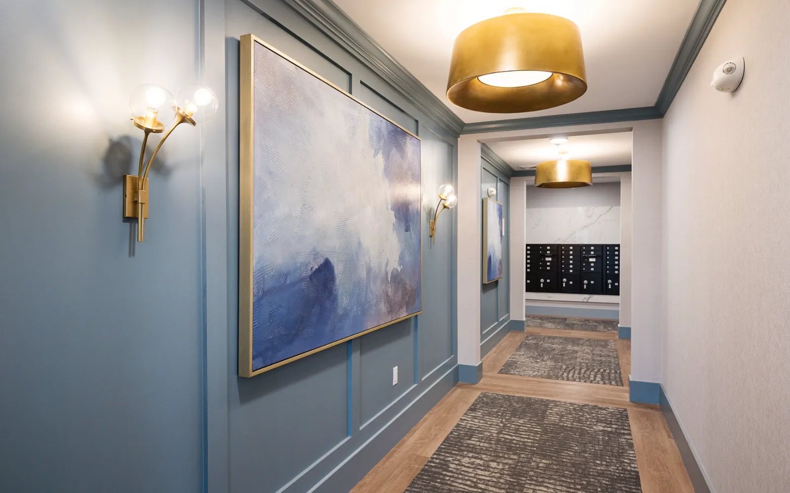 Designer hallway with gold fixtures and framed art in Sawyer's Reach condo Plymouth MA