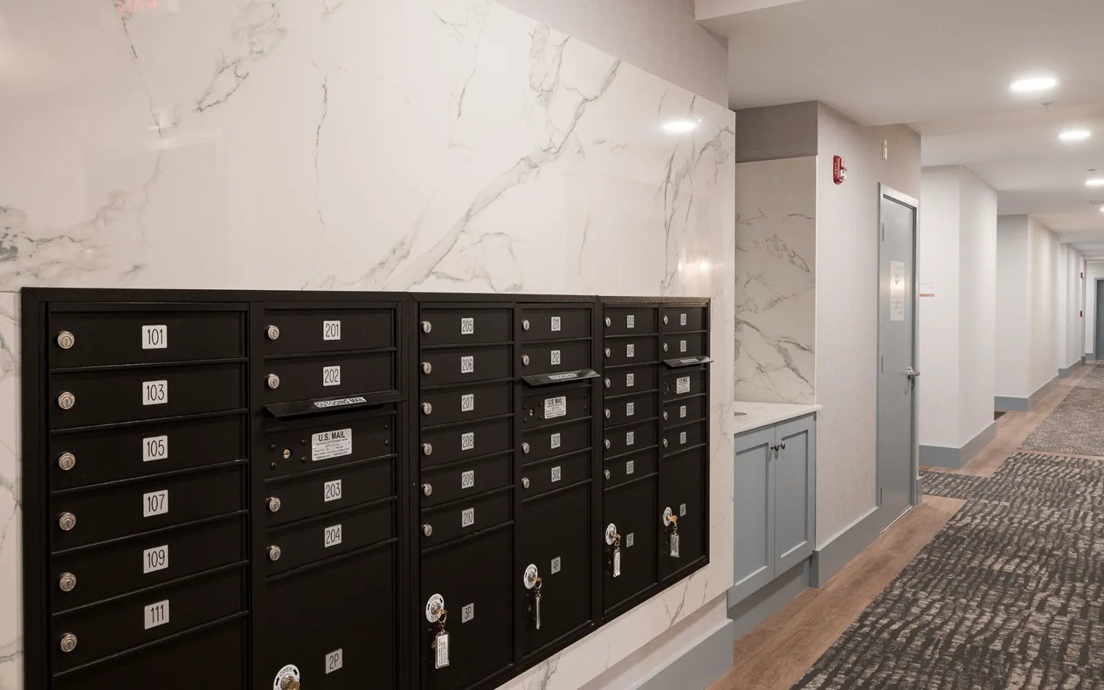 Package lockers and marble-clad mailroom in Sawyer's Reach condo building Plymouth MA