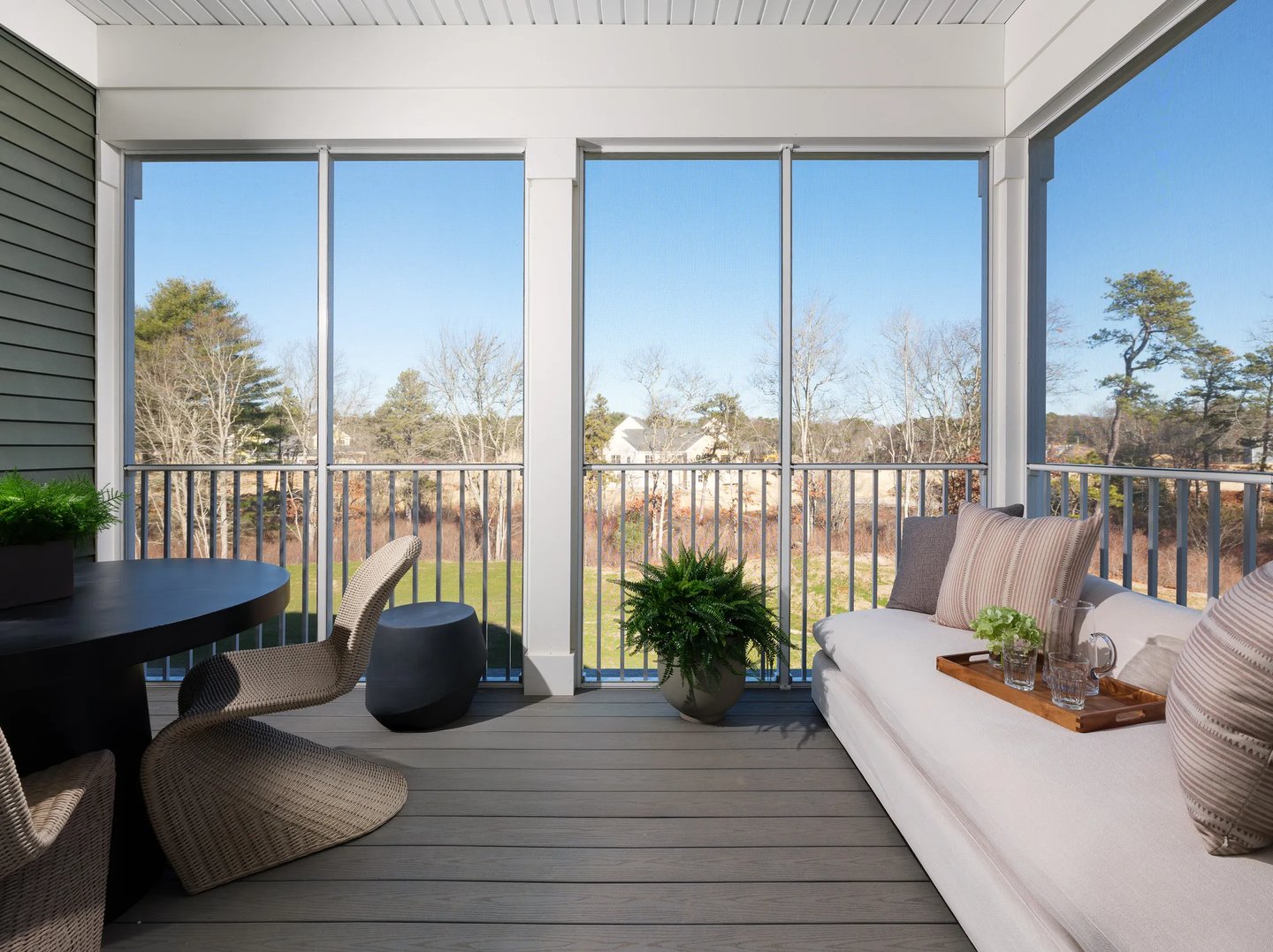 Screened porch with outdoor dining and lounge seating at Alden's Reach condos in Plymouth MA