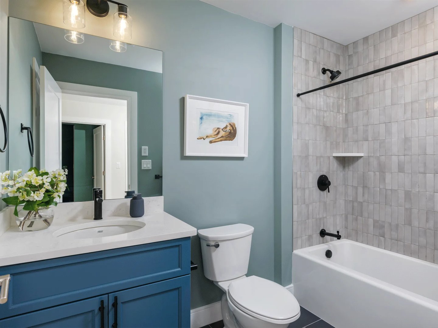 Full bath in a Larkwood townhome in Raynham MA with blue vanity and subway tile tub surround