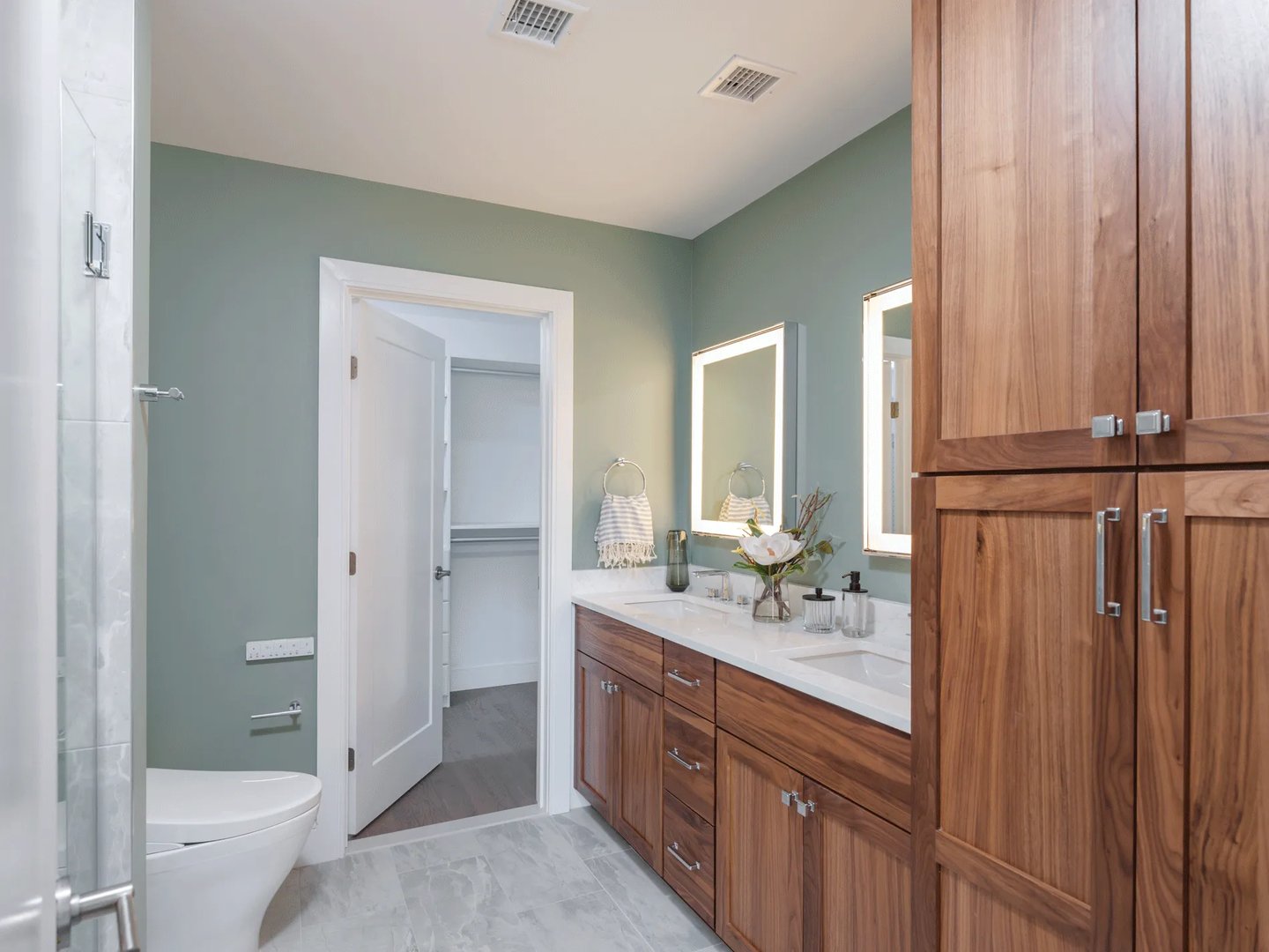 Primary bath in a Larkwood townhome in Raynham MA with walnut double vanity and walk-in closet
