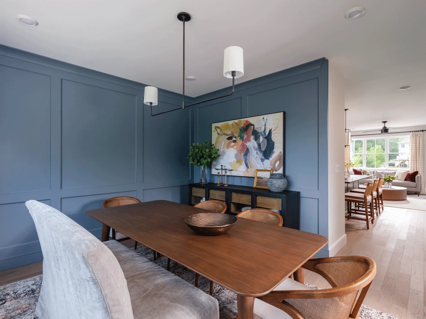 Dining room in a Larkwood townhome in Raynham MA with navy wainscoting and walnut table