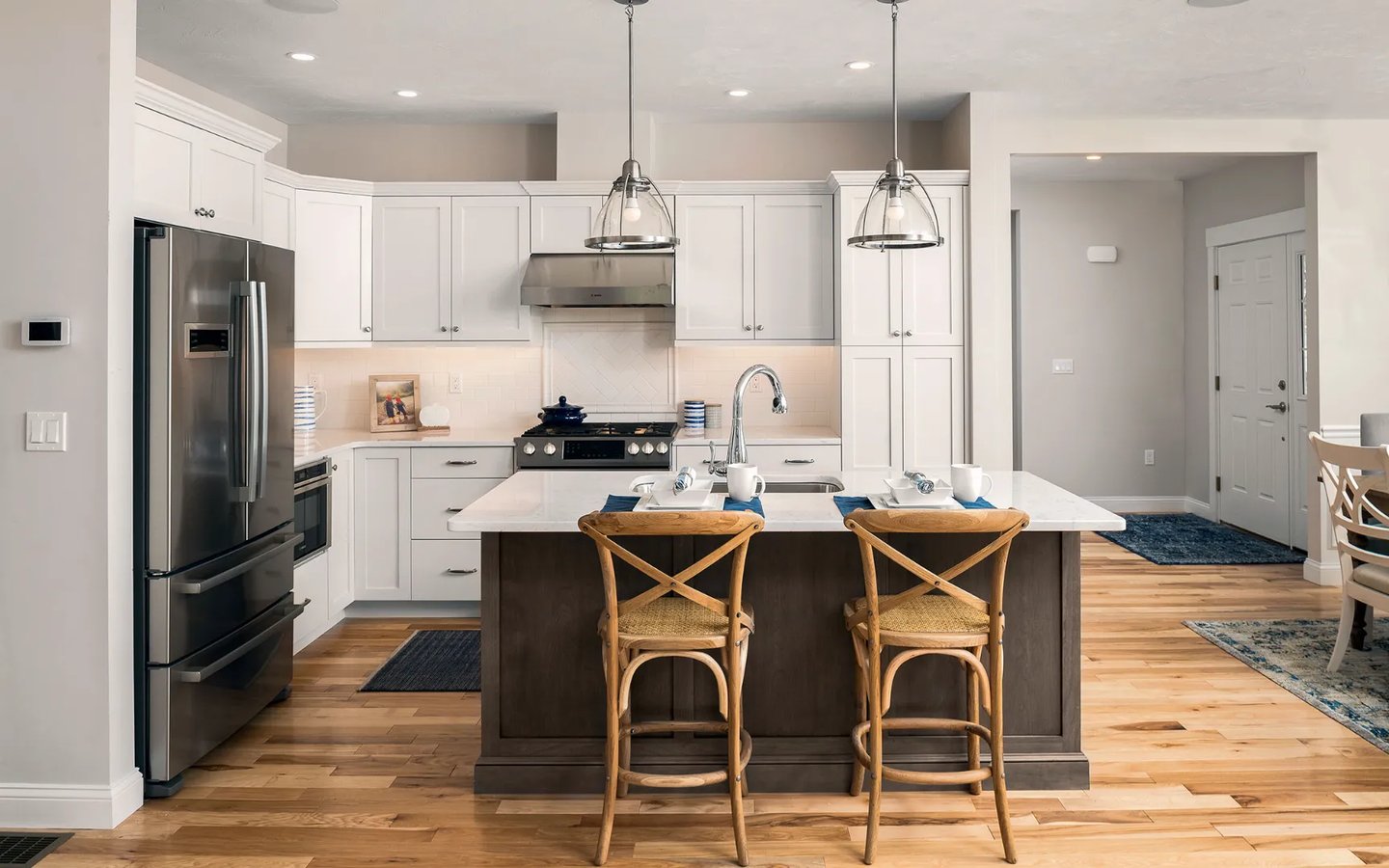 Chef kitchen with island seating and stainless appliances in Summer Reach model home Plymouth MA