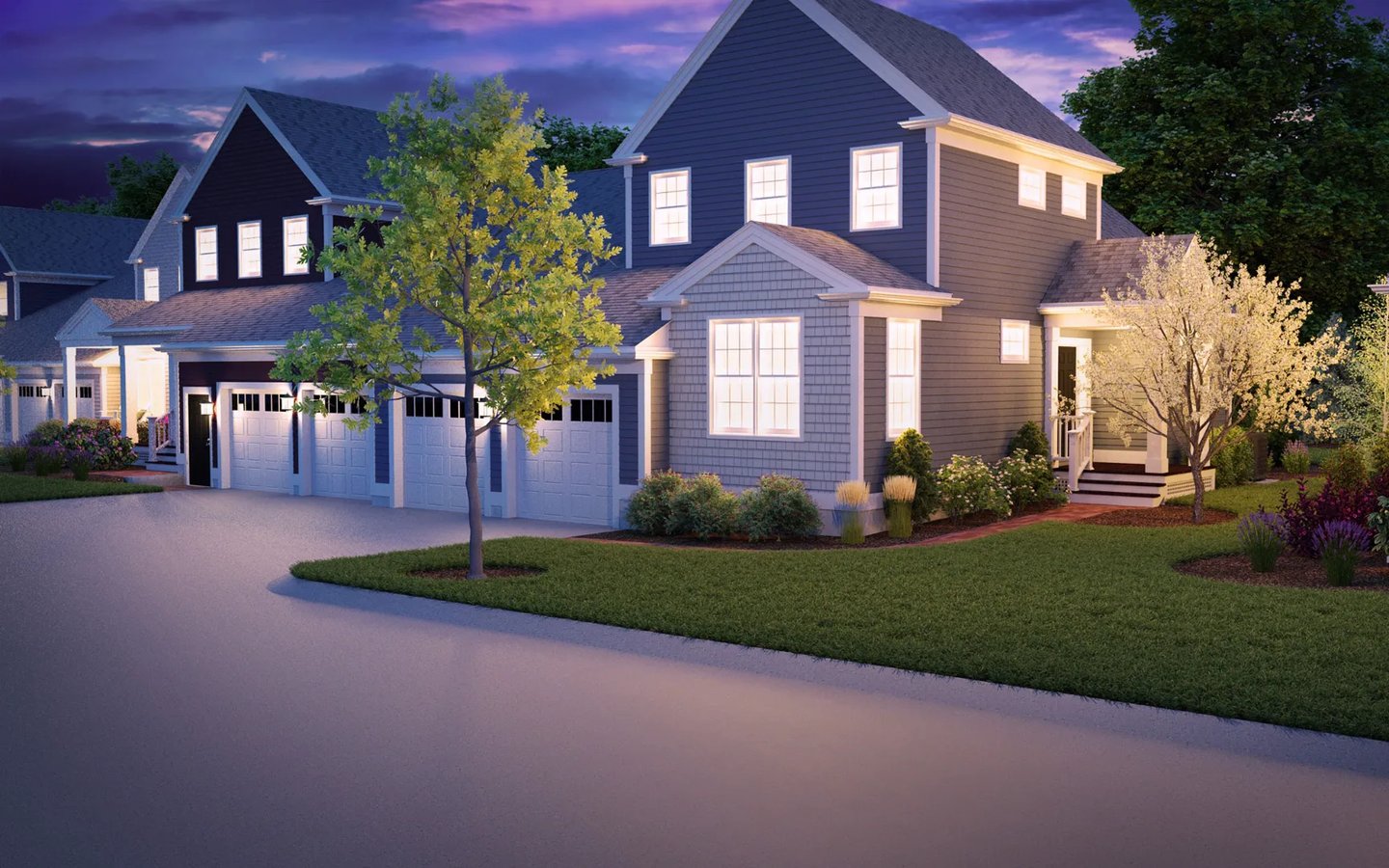 Tree-lined streetscape at Summer Reach showing attached homes with garages at dusk in Plymouth MA